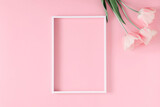 Beautiful composition, spring flowers. Blank frame for text, pink tulips flowers on pastel pink background. Valentine's Day, Easter, Birthday, Happy Women's Day. Flat lay, top view, copy space 