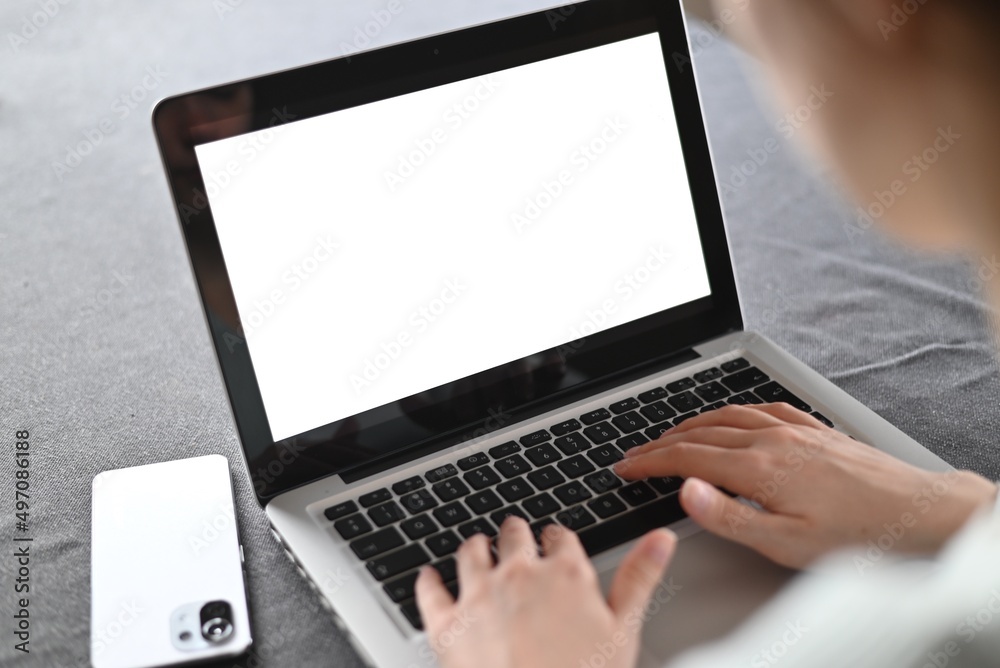 mockup image blank screen computer with white background for advertising text, hand woman using laptop contact business search information on desk at home.marketing and creative design mockup image blank screen computer with white background for advertising text, hand woman using laptop contact business search information on desk at home.marketing and creative design
