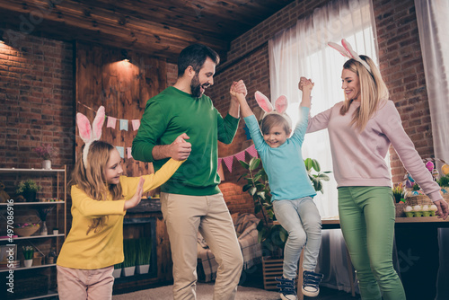 Photo of full idyllic friendly family parents hold hands kids enjoy festive atmosphere house indoors