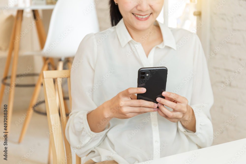 using cell phone hand holding mobile texting message contact us.chatting,search internet information in office.technology device communication connecting