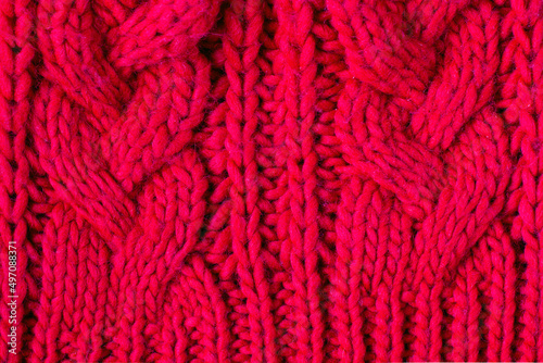Red knitted woolen background for your design. Knit fabric pattern of sweater