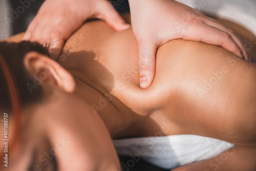 Body care. The masseur gives a young girl a massage, rests in the spa, close-up. Skin care concept