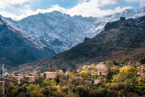 The village of Feliceto in the Balagne region of Corsica with snow capped mountains in the distance