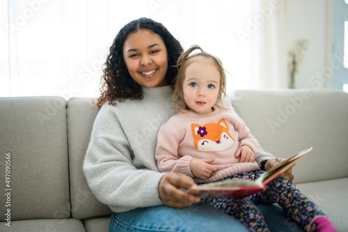 babysitter black woman read book with little child girl photo