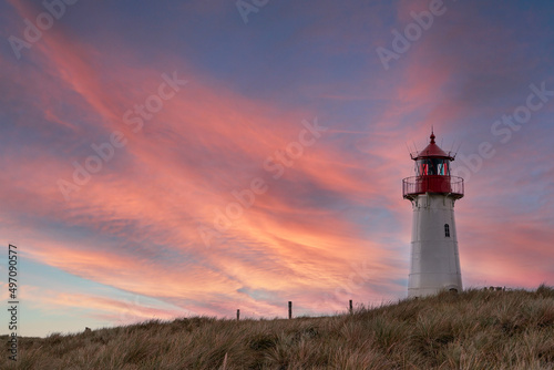 Lighthouse List-West on the island Sylt at sunset. Dramatic sunset sky and lighthouse.