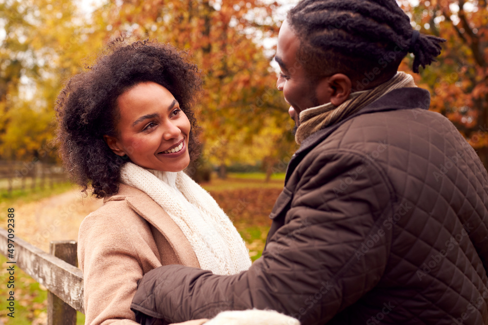 Loving Couple On Walk Through Autumn Countryside Resting On Fence Together Loving Couple On Walk Through Autumn Countryside Resting On Fence Together