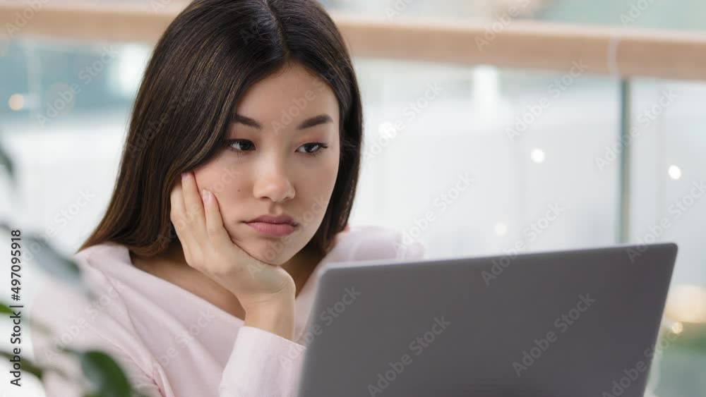 Tired sad upset female face exhausted dissatisfied asian woman manager worker student girl looking at laptop with bored tries to work in morning in office read bad news boring working routine laziness Tired sad upset female face exhausted dissatisfied asian woman manager worker student girl looking at laptop with bored tries to work in morning in office read bad news boring working routine laziness