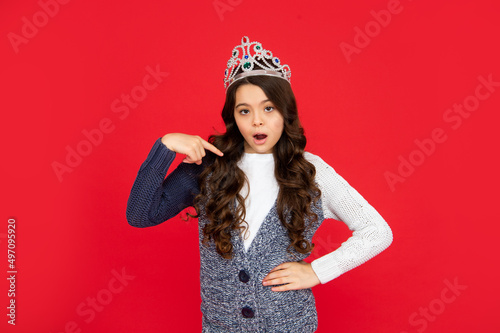 selfish child in crown. self confident queen. expressing smug. arrogant princess in tiara. photo