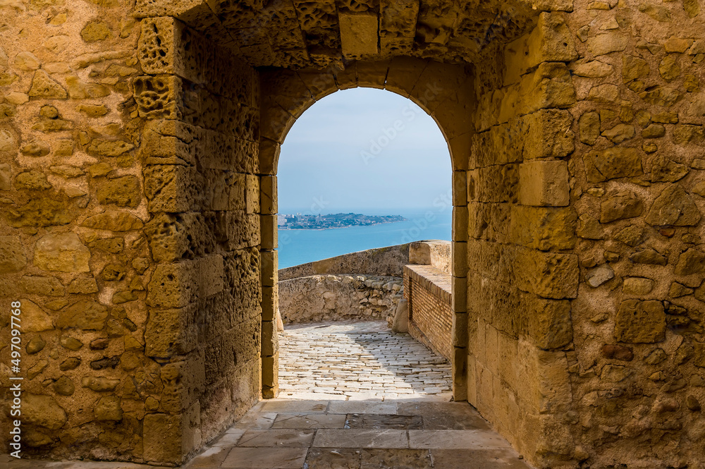 A view through an entrance in the castle of Saint Ferran above Alicante on a spring day