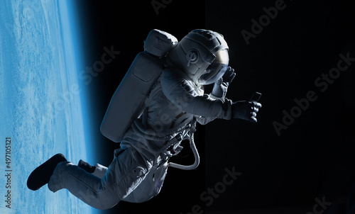 Female astronaut having a video call on her phone while performing spacewalk in open space  Earth in the background