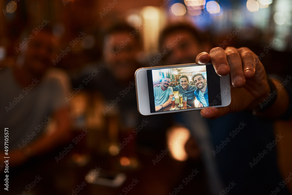 This is happening guys. Closeup of a group of cheerful young friends taking a self portrait together while enjoying beer together at a bar during the night. This is happening guys. Closeup of a group of cheerful young friends taking a self portrait together while enjoying beer together at a bar during the night.