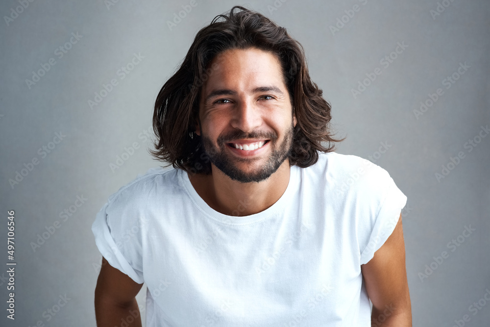 The smile that melted a thousand hearts. Studio shot of a handsome young man posing against a grey background. The smile that melted a thousand hearts. Studio shot of a handsome young man posing against a grey background.