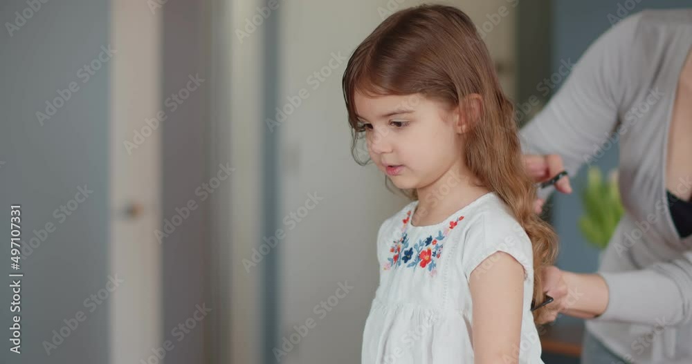 Cute toddler girl getting by haircut by mom. 4K footage. Cute toddler girl getting by haircut by mom. 4K footage.