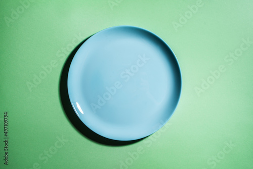Blue empty plate on green background