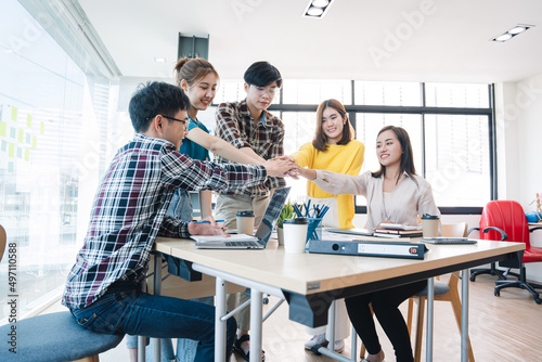 young business people putting their hands together. Stack of hands. Unity and teamwork concept. © Daenin