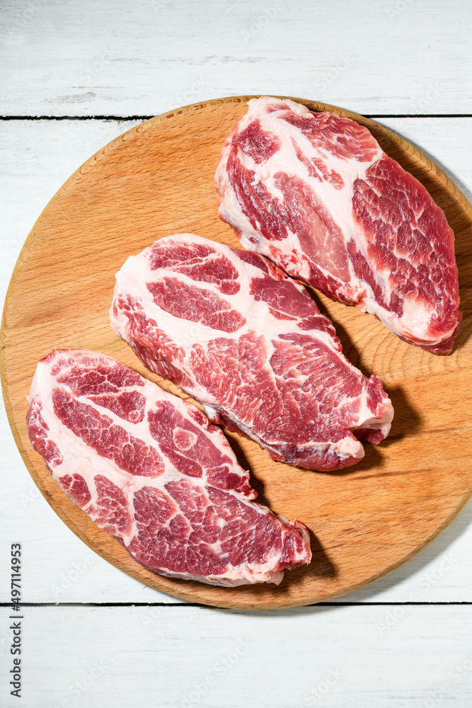 Sliced raw pork meat on wooden surface, top view Sliced raw pork meat on wooden surface, top view