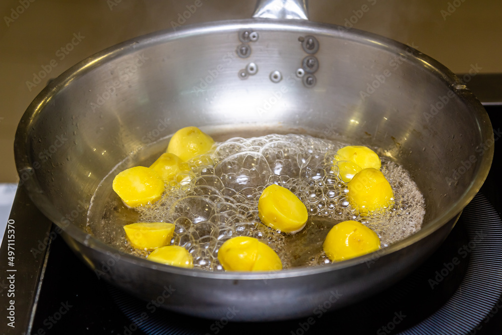 The cook is frying potato balls in a frying pan The cook is frying potato balls in a frying pan