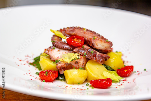 Traditional Spanish octopus salad with potatoes, drizzled with olive oil