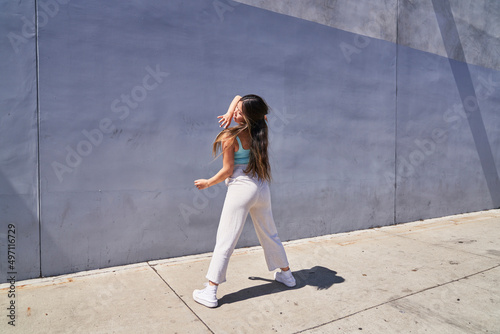 woman dancing facing gray blue wall 