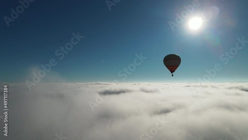 First person aerial view of beautiful air hot balloon flying high in the clouds during sunny hot weather. Scenery, skyline. Adventure concept.