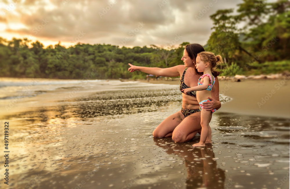Fototapeta premium happy family at the beach a mother child daughter having fun at sunset