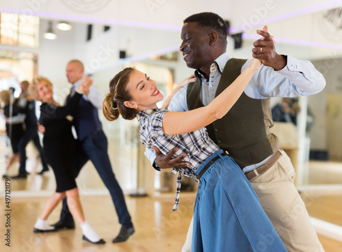 Man and woman performing ballroom dance in dancing room photo