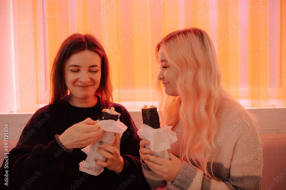 LGBT Lesbian couple eat sushi rolls in asian cafe LGBT Lesbian couple eat sushi rolls in asian cafe