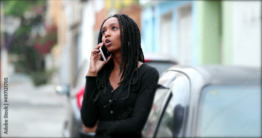 Mixed race teen girl speaking on phone outdoors in street