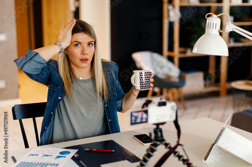 Young business woman recording video for her vlog at home.