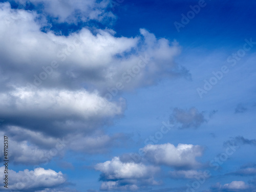 Fluffy white clouds on a vibrant blue sky