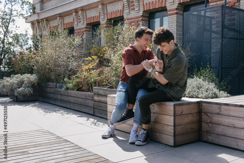 Gay couple laughing in a terrace Gay couple laughing in a terrace