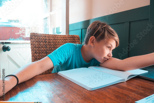 Boy leaning on table with notebook photo