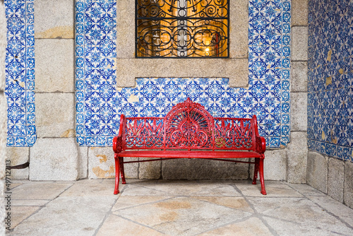 Portugal, Porto, Red bench in front of wall covered with azulejos photo