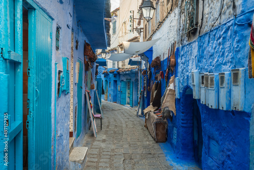Morocco, Chefchaouen, Narrow alley and souvenirs for sale at blue buildings © Image Source