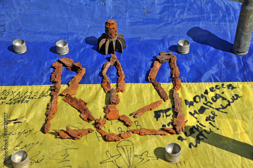 Emblem of ukraine is laid out from the fragments of mines and shells against the background of the battle flag. Russian-Ukrainian war.