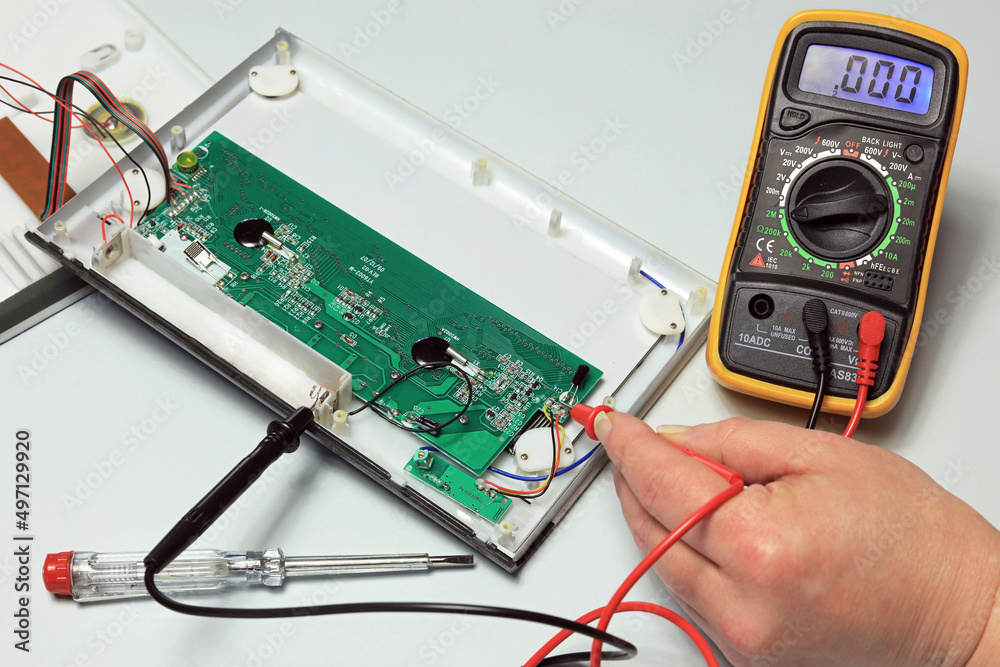 electrician with multimeter testing a circuit board Stock-foto | Adobe Stock