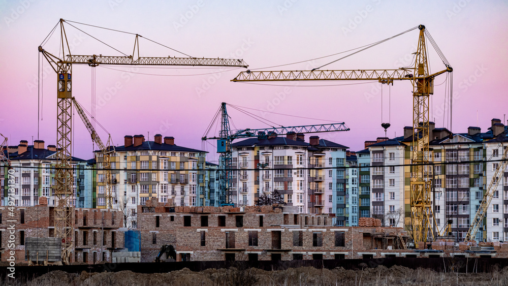 Large construction site with several cranes working on a construction complex