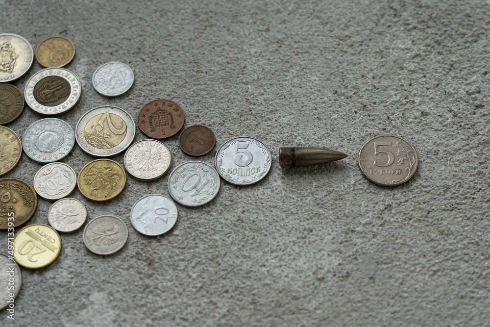 A bullet flying towards a Russian coin from the side of a Ukrainian coin which has behind the coins of the whole world. The concept of confrontation between countries. financial war. A bullet flying towards a Russian coin from the side of a Ukrainian coin which has behind the coins of the whole world. The concept of confrontation between countries. financial war.