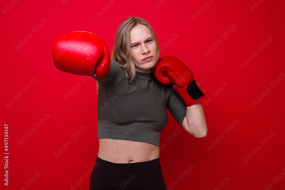 Sporty young woman in red boxing gloves is fooling around Sporty young woman in red boxing gloves is fooling around