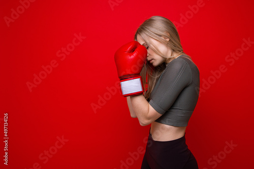 Athletic young woman in red boxing gloves in training