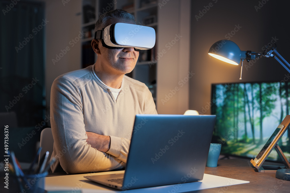 Man sitting at desk and experiencing virtual reality