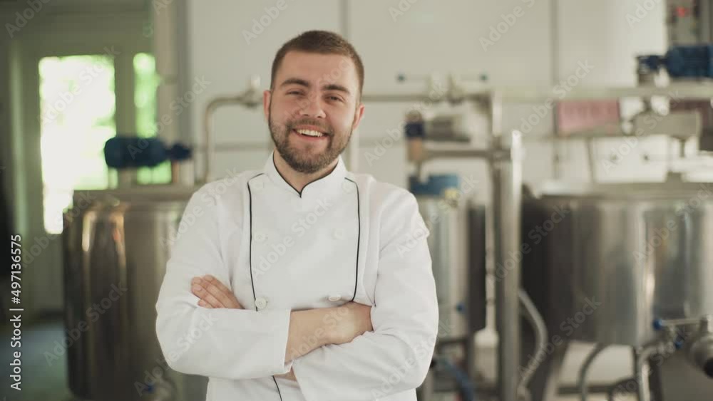 Portrait of a cheese factory worker. The technologist in a white coat looks at the camera and puts his hand on his arm. Cheese production technology Portrait of a cheese factory worker. The technologist in a white coat looks at the camera and puts his hand on his arm. Cheese production technology