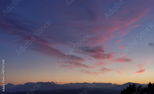 Tramonto blu e rosso nel cielo sopra le valli le colline e le montagne dell’Appennino photo