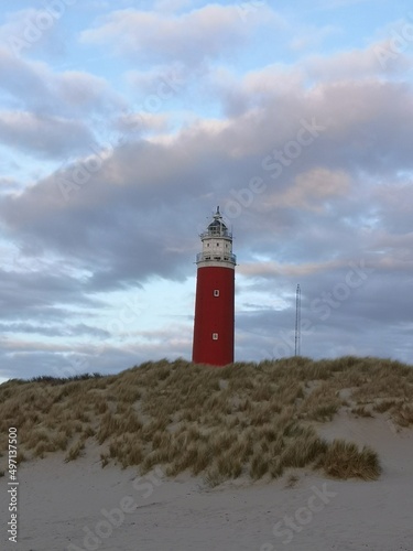 The lighthouse of De Cocksdorp of Texel, up close with a colorful cloudy sky.