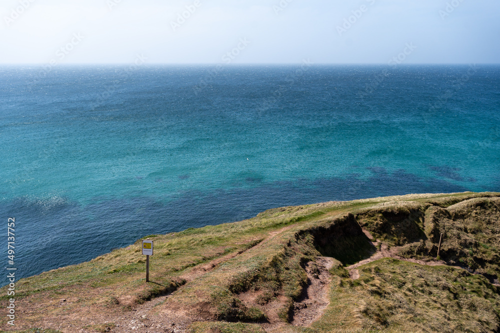 Cornwall coast with steep cliffs, beach and clear water in England, United Kingdom, beautiful hiking and biking trails for tourism and travel