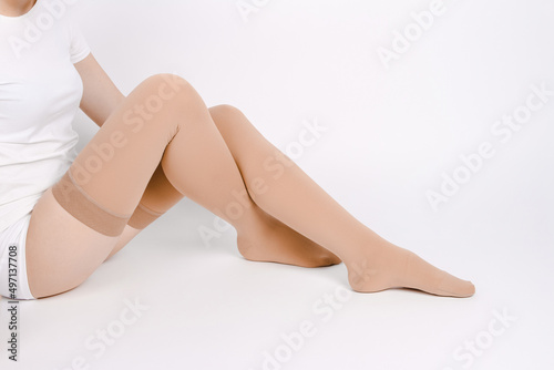 Beige compression stockings isolated on a white background. photo