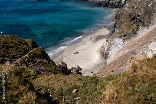 Cornwall coast with steep cliffs, beach and clear water in England, United Kingdom, beautiful hiking and biking trails for tourism and travel photo