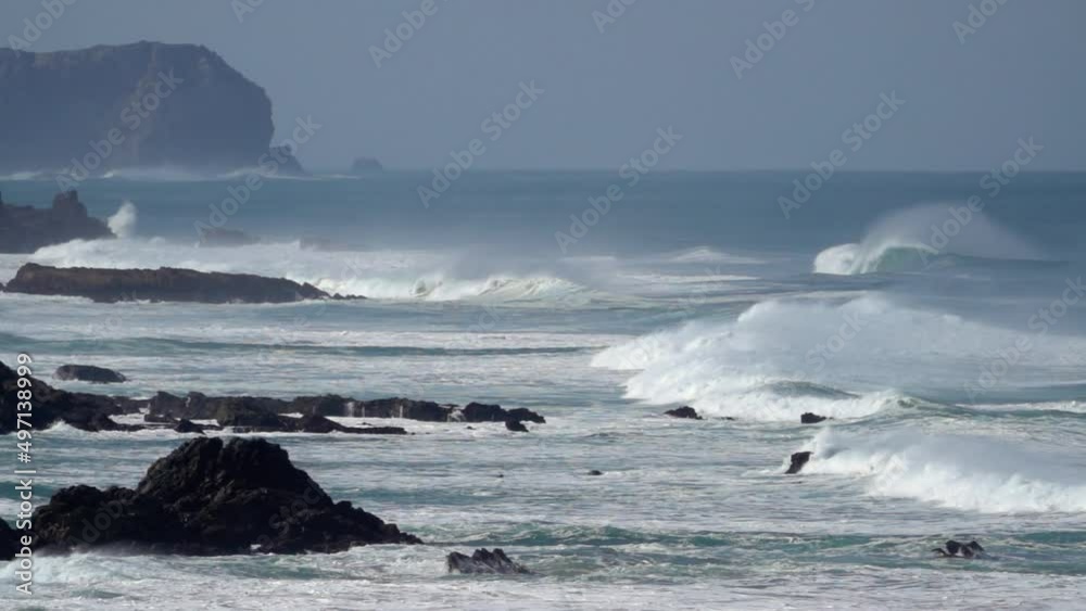 super slow motion shot of giant wave breaking at the beach coastline of portugal