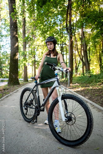Pretty young slim woman on a bicycle rest after activity in the forest © RomanR