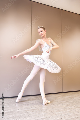 caucasian ballet dancer practice ballet positions in professional tutu skirt of white swan. young beautiful woman ballet dancer in tutu practice ballet positions